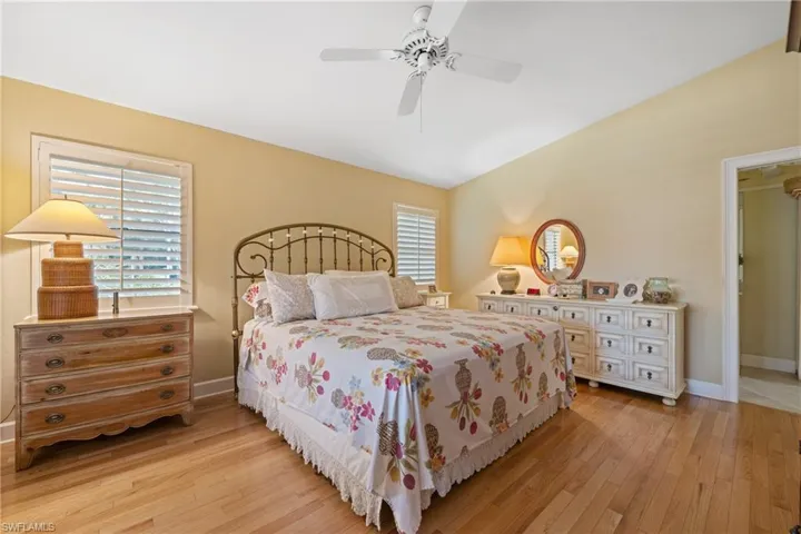 Bedroom with lofted ceiling, light hardwood / wood-style floors, and ceiling fan