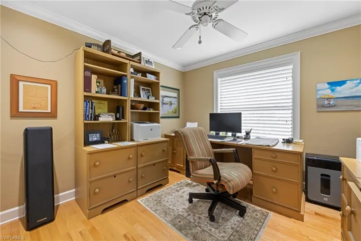 Office space with ceiling fan, light hardwood / wood-style flooring, and ornamental molding