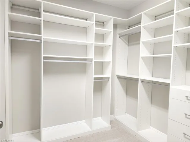 Walk in closet with lots of shelving