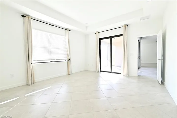 Spare room featuring light tile patterned floors and a tray ceiling