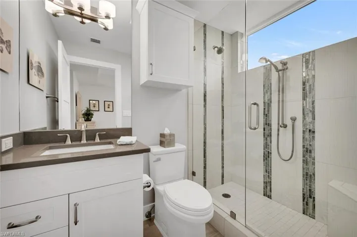Bathroom with vanity, toilet, and an enclosed shower
