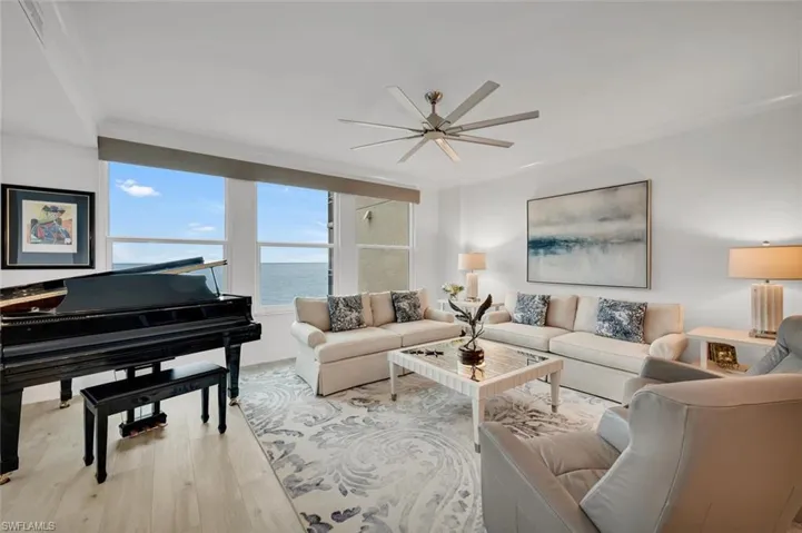 Living room with crown molding, a water view, ceiling fan, and light hardwood / wood-style flooring