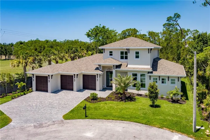 View of front of property with decorative driveway, a garage, a shingled roof, and a front yard