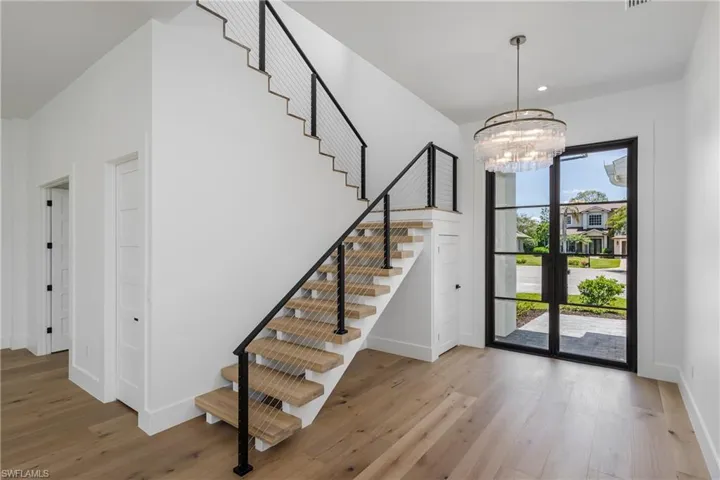 Foyer entrance featuring stairs, wood finished floors, a chandelier, and recessed lighting