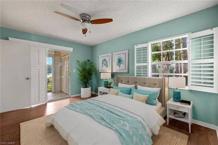Bedroom featuring multiple windows, ceiling fan, hardwood / wood-style floors, and a textured ceiling