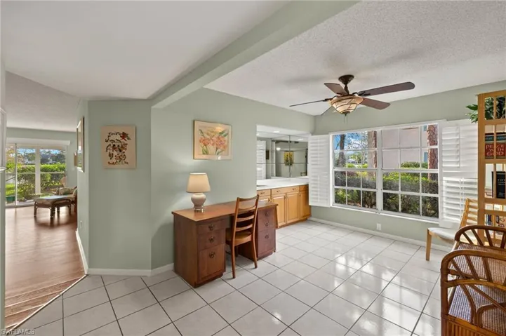 Tiled office space with ceiling fan and a textured ceiling
