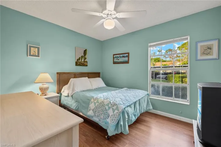 Bedroom featuring ceiling fan, hardwood / wood-style floors, and a textured ceiling