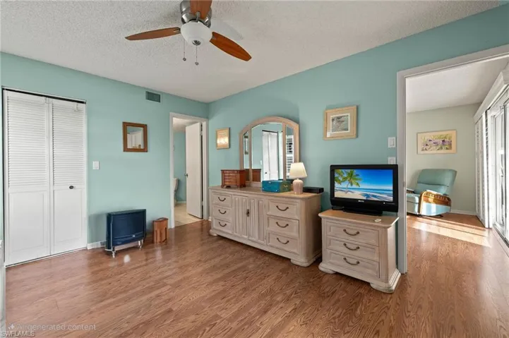 Bedroom featuring ceiling fan, a closet, a textured ceiling, and light wood-type flooring