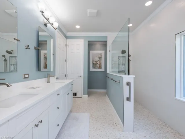 Bathroom featuring crown molding and dual vanity