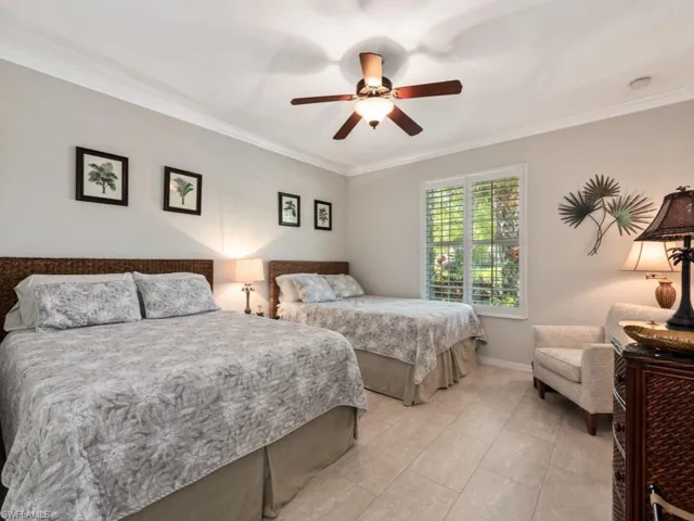 Tiled bedroom with ornamental molding and ceiling fan