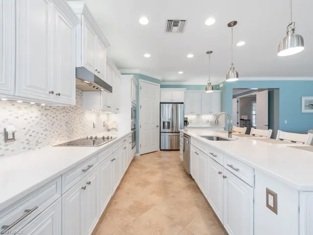 Kitchen featuring sink, tasteful backsplash, decorative light fixtures, and appliances with stainless steel finishes