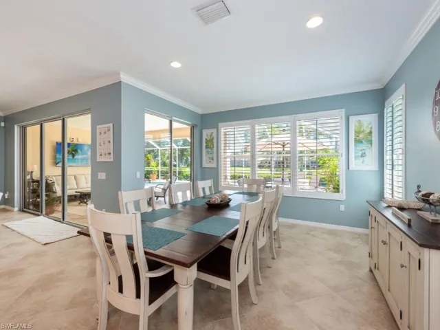 Tiled dining room featuring plenty of natural light and crown molding