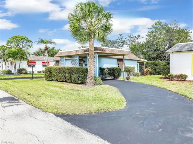 Ranch-style house featuring driveway, stucco siding, a front yard, and a carport