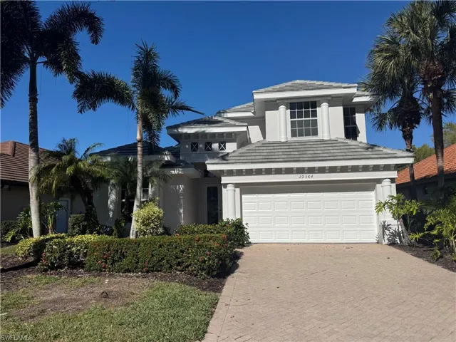 View of front of property with stucco siding, decorative driveway, a tiled roof, and an attached garage