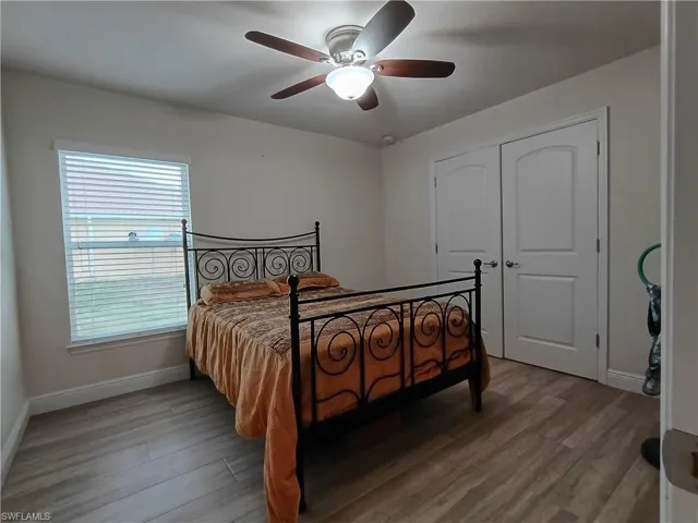 Bedroom featuring wood finished floors, ceiling fan, and a closet