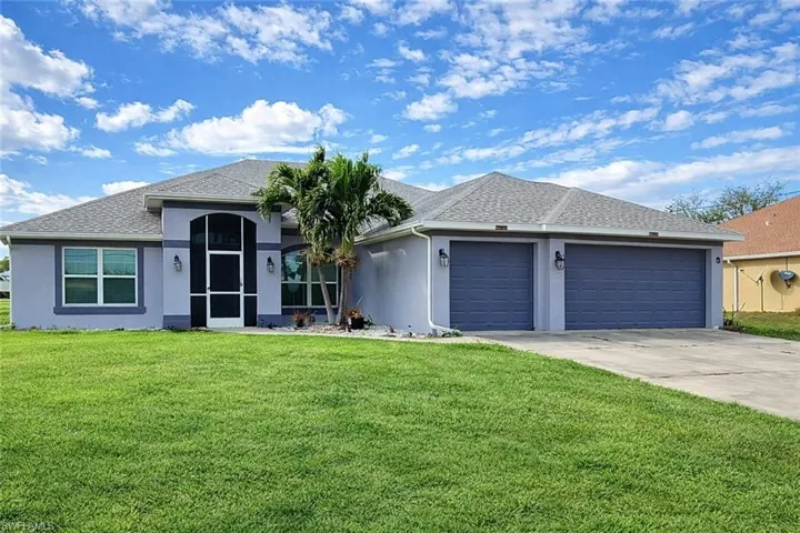 Ranch-style home with stucco siding, a front lawn, and driveway