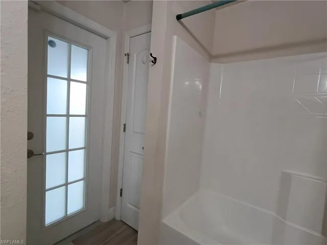 Full bath with shower / tub combination and wood finished floors