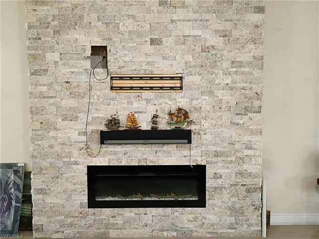 Detailed view of a stone fireplace and baseboards