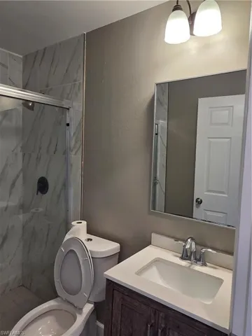 Bathroom with vanity and a marble finish shower