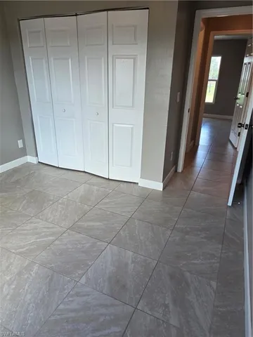 Unfurnished bedroom with a closet and baseboards