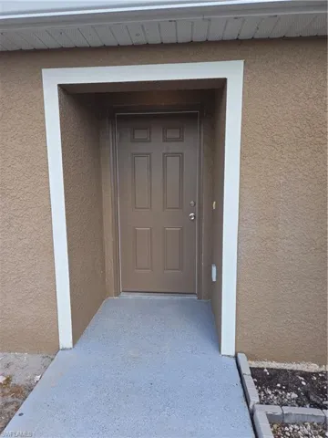 Entrance to property with stucco siding