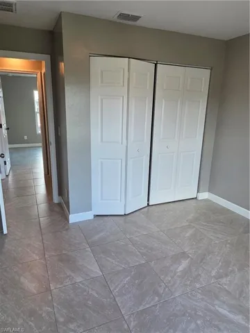 Unfurnished bedroom with a closet and baseboards