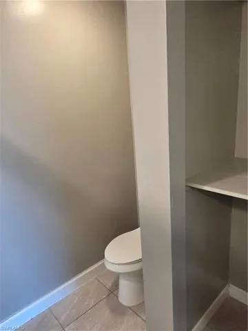 Bathroom with baseboards and light tile patterned floors