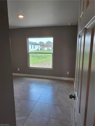 Empty room with recessed lighting and light tile patterned floors