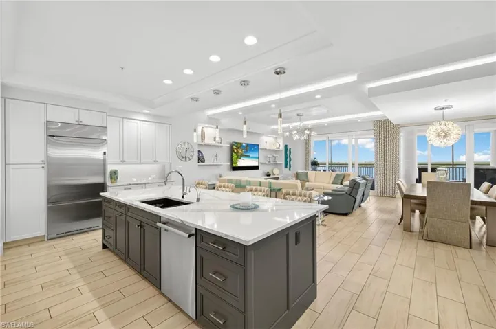 Kitchen with a tray ceiling, white cabinetry, a chandelier, and recessed lighting