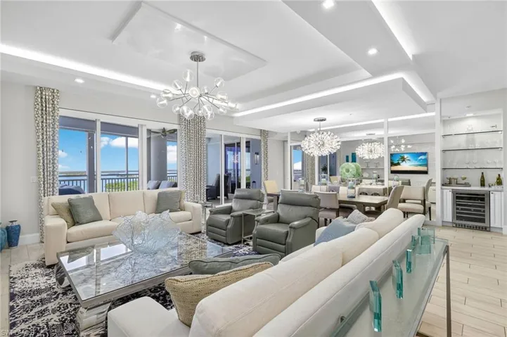 Living room featuring a chandelier, a tray ceiling, and beverage cooler