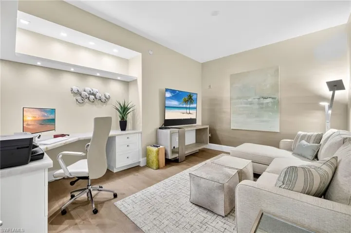office room with light wood finished floors, built in study area, and recessed lighting
