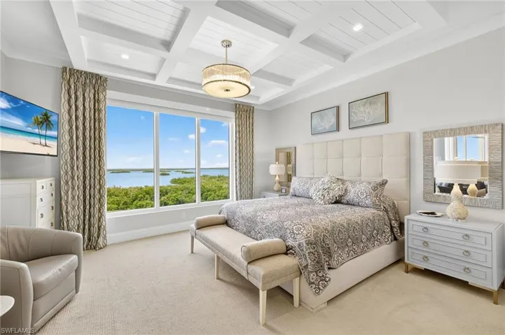 Bedroom with carpet floors, a water view, beamed ceiling, and coffered ceiling
