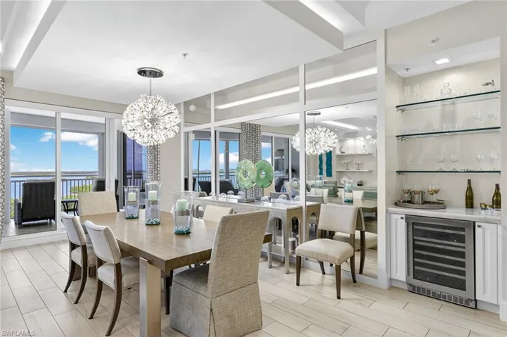 Dining space with beverage cooler, a chandelier, and wood finish floors