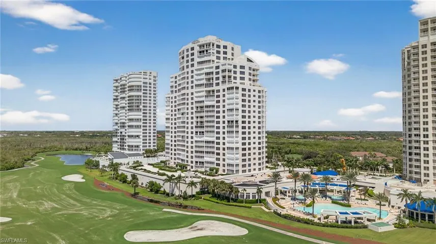 View of apartment building / complex featuring golf course view and a water view