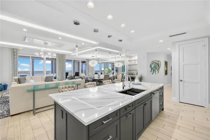 Kitchen featuring a raised ceiling, open floor plan, a chandelier, healthy amount of natural light, and recessed lighting