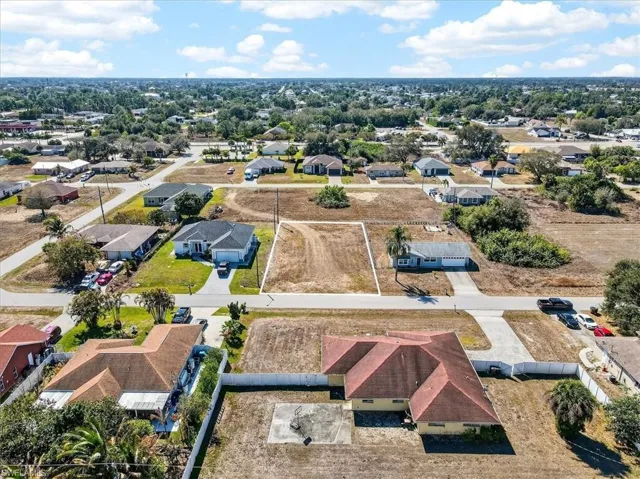 Aerial view of property and surrounding area with nearby suburban area