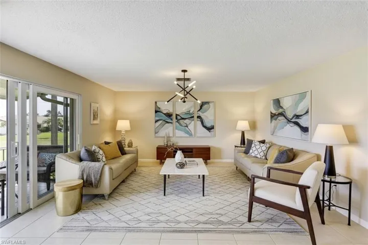 Living area virtual staged -featuring suspended lighting, a textured ceiling, and light tile patterned flooring