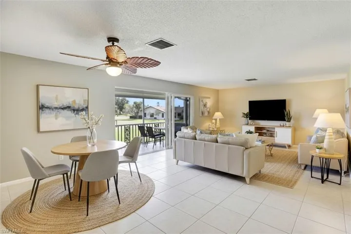 355-Palm-Dr-732-Naples-FL-Living area-virtual staged- with light tile patterned flooring, a textured ceiling, and a ceiling fan