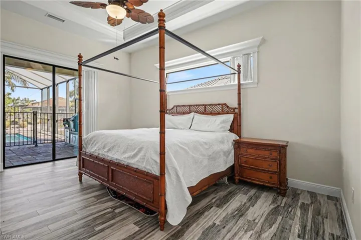 Bedroom with wood finished floors, access to exterior, and a ceiling fan