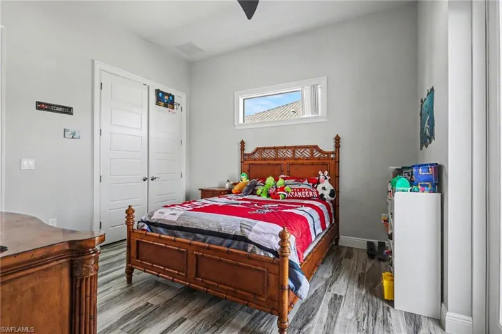 Bedroom with dark wood finished floors, a closet, and ceiling fan