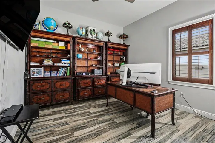 Home office with light wood finished floors and a ceiling fan