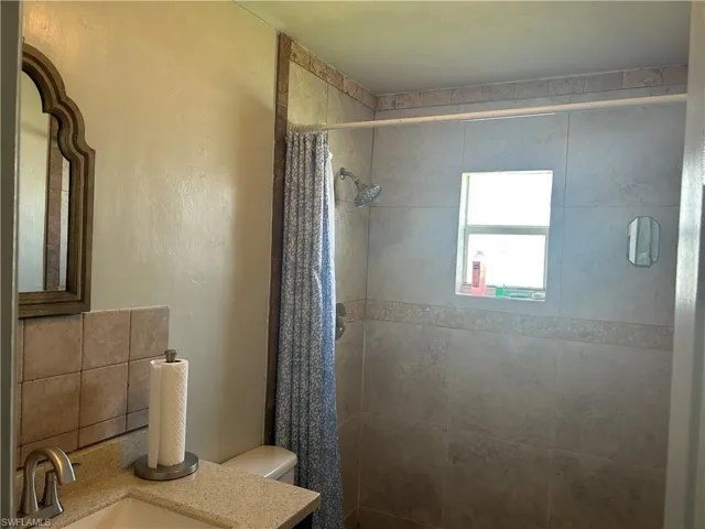 Guest bathroom with vanity, custom tiled stand in shower