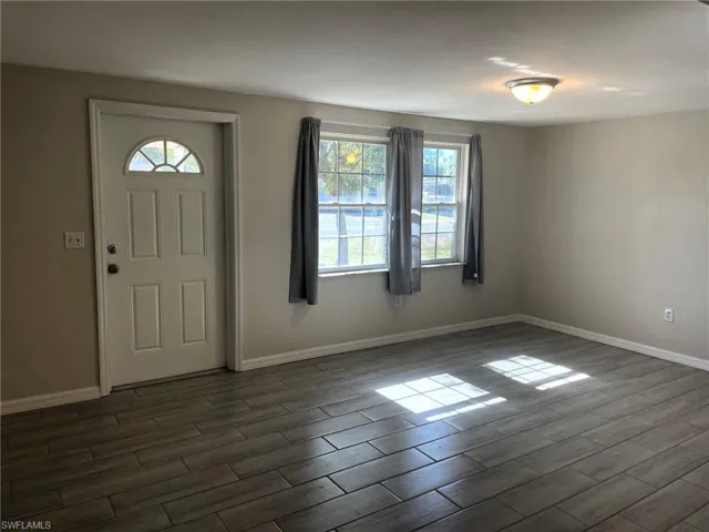 Entrance foyer featuring baseboards and wood finish floors