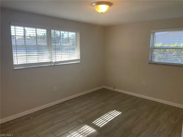 Unfurnished room featuring baseboards and wood finish floors