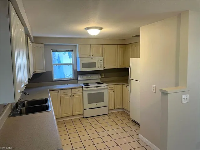 Kitchen featuring white appliances, light countertops, and light tile patterned floors