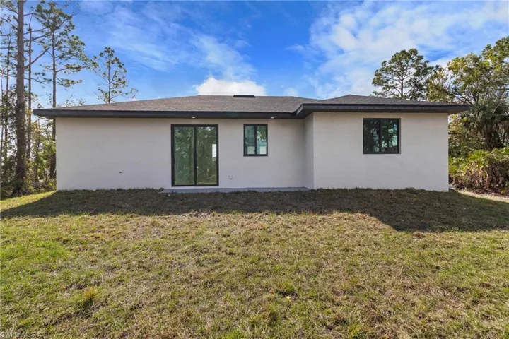 Back of property with a yard