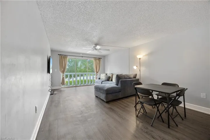 Living room with a ceiling fan, and vinyl flooring.