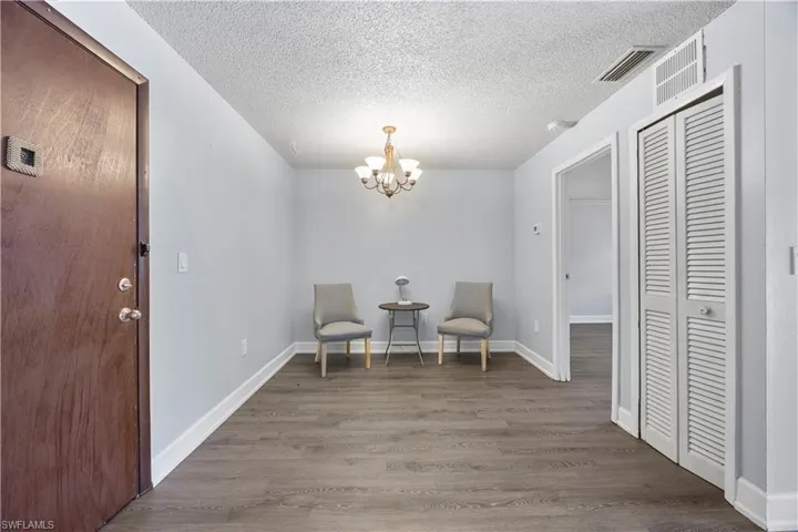 Sitting room or dining area with a chandelier, vinyl flooring.
