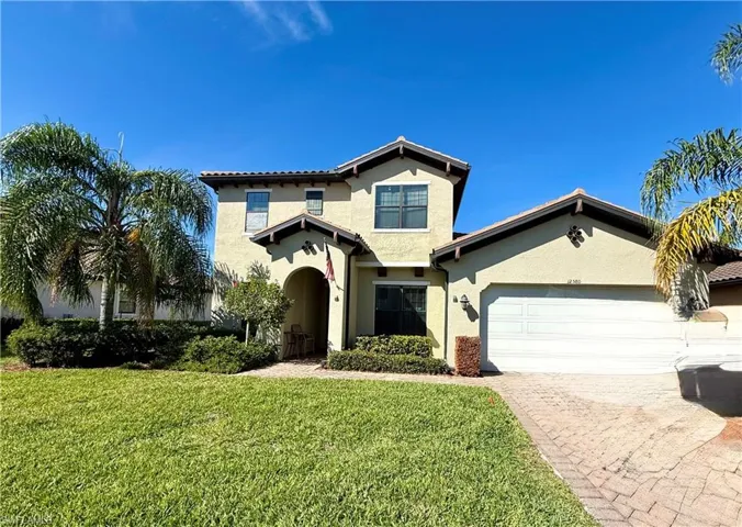 Mediterranean / spanish-style home featuring a front yard, stucco siding, driveway, and a garage