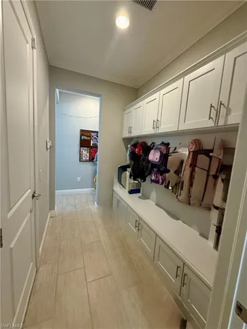 Mudroom with crown molding and baseboards